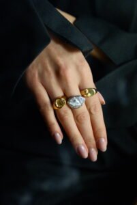 Srebrny pierścionek handmade z dużą, naturalną perłą barokową o nieregularnym kształcie na białym tle, marka Her-Ring