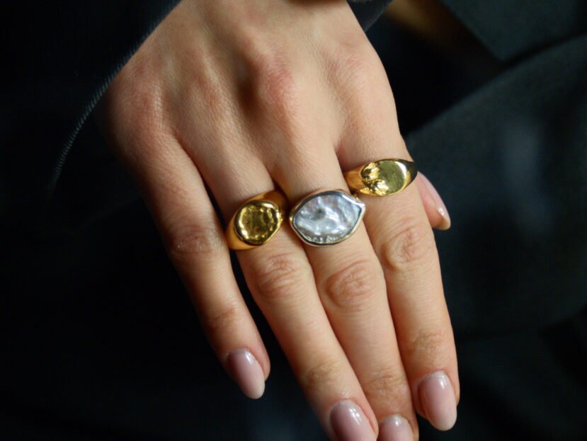 Srebrny pierścionek handmade z dużą, naturalną perłą barokową o nieregularnym kształcie na białym tle, marka Her-Ring