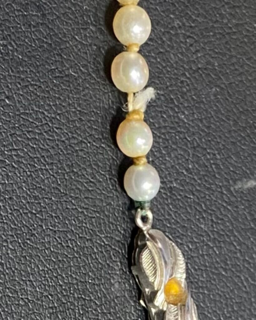 Wyciagnięty sznur pereł, który został podklejany przez właścicielkę. a musi być na nowo zapętelkowany