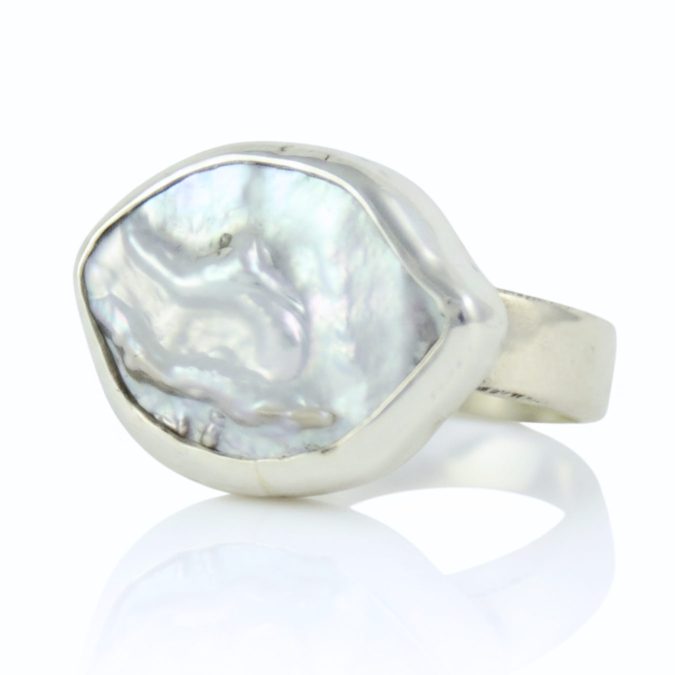 Srebrny pierścionek handmade z dużą, naturalną perłą barokową o nieregularnym kształcie na białym tle, marka Her-Ring