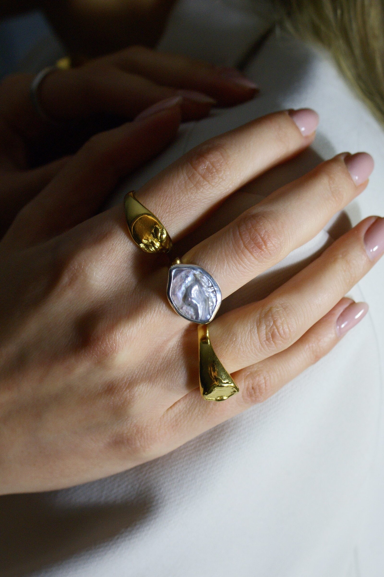 Srebrny pierścionek handmade z dużą, naturalną perłą barokową o nieregularnym kształcie na białym tle, marka Her-Ring