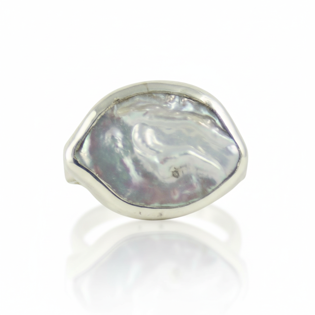 Srebrny pierścionek handmade z dużą, naturalną perłą barokową o nieregularnym kształcie na białym tle, marka Her-Ring