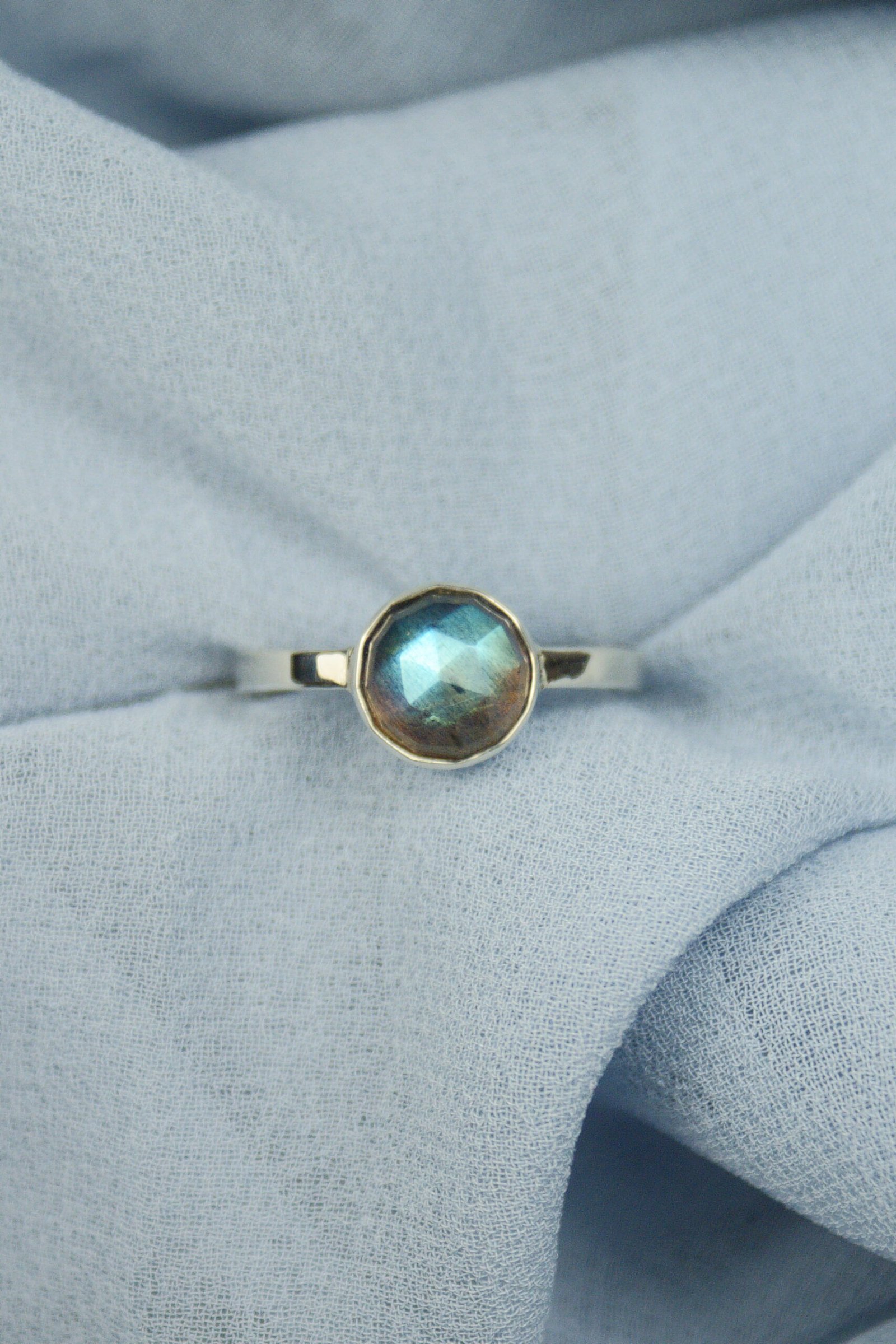 Detal szlifu rozetowego labradorytu w minimalistycznej oprawie ze srebra 925, polskie rzemiosło jubilerskie.