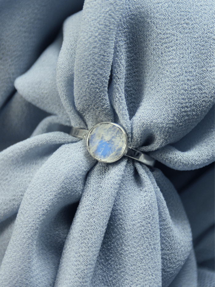 Srebrny pierścionek z kamieniem księżycowym na błękitnym tle, polskie rękodzieło Her-Ring.