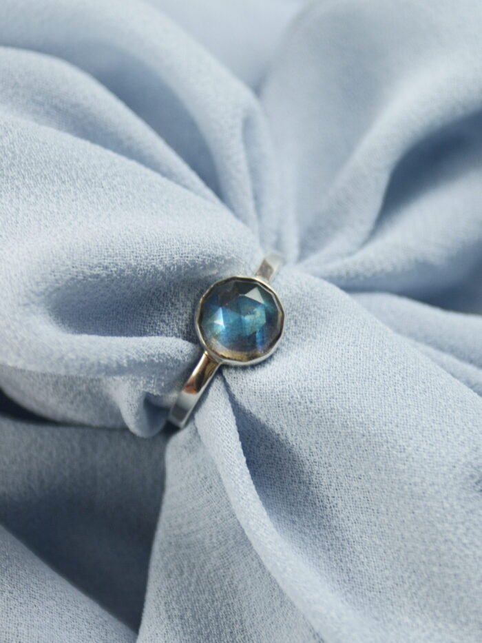 Detal szlifu rozetowego labradorytu w minimalistycznej oprawie ze srebra 925, polskie rzemiosło jubilerskie.