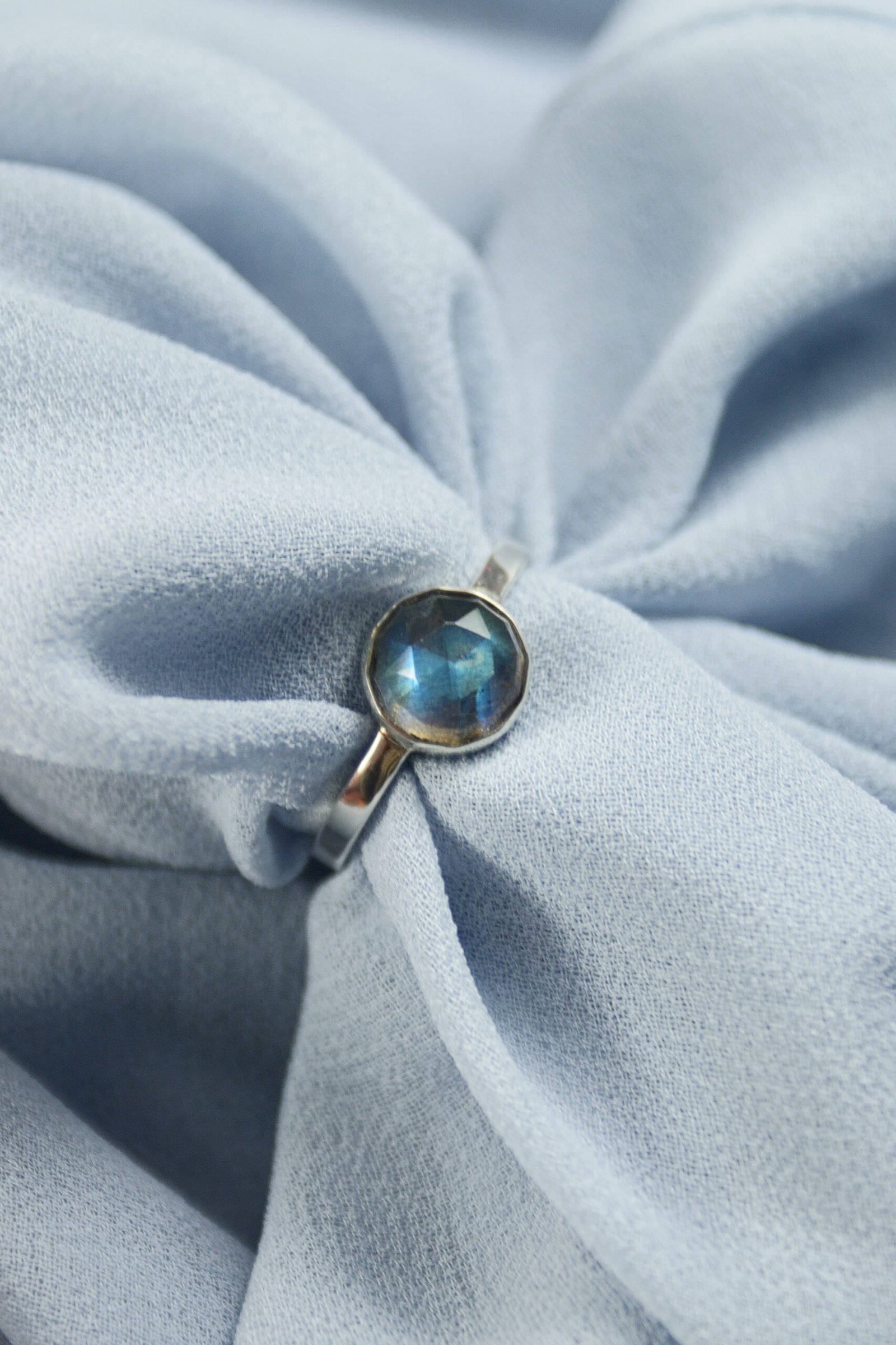 Detal szlifu rozetowego labradorytu w minimalistycznej oprawie ze srebra 925, polskie rzemiosło jubilerskie.