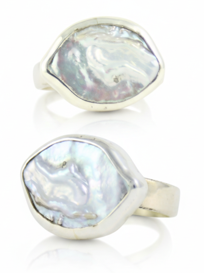 Srebrny pierścionek handmade z dużą, naturalną perłą barokową o nieregularnym kształcie na białym tle, marka Her-Ring