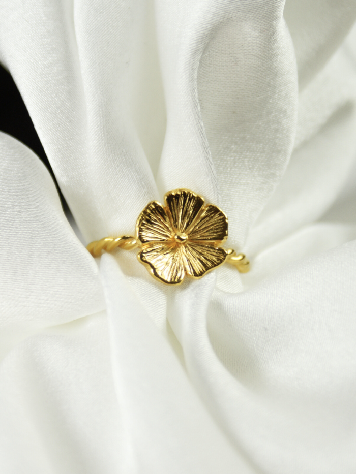 Złoty pierścionek z kwiatem Cosmos HerRing, próba 585, ręcznie rzeźbione płatki z wyraźnymi żyłkami, biżuteria floralna na kobiecej dłoni w świetle słońca.